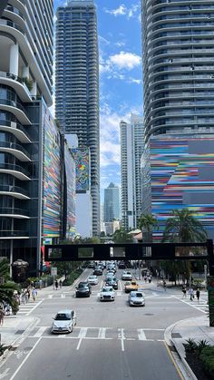 cars are driving down the street in front of tall buildings