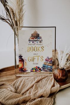 there is a sign that says books and gifts on the table next to some feathers