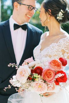 the bride and groom are standing close to each other holding flowers in their bouquets