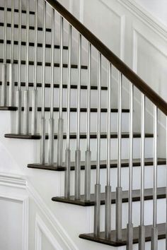 a white staircase with metal handrails and black rails