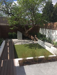 an outdoor garden with grass and wooden decking