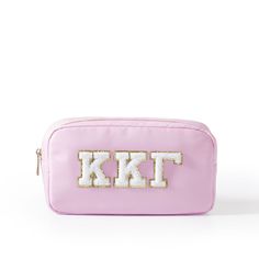 a pink cosmetic bag with the letter kt on it and sequins in white letters