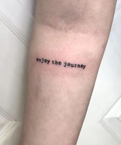 a tattoo saying enjoy the journey on someone's arm