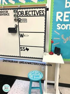 a desk and chair in front of a bulletin board