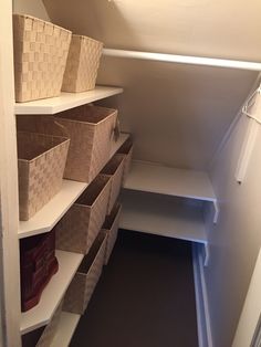 an empty closet with several baskets and bins on the shelves, along with other items