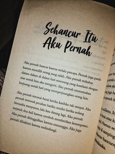 an open book with the words shanour tu aku penah written in black