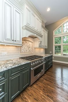 an empty kitchen with white cabinets and wood flooring is pictured in this image from the front view