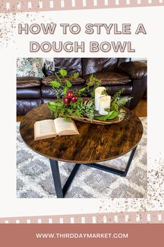 a coffee table with candles and flowers on it in front of a brown leather couch