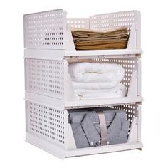 three white shelves with clothes and folded towels on them, one is open to the other