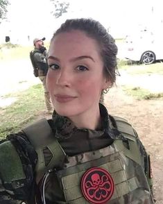 a woman dressed in an army uniform posing for the camera