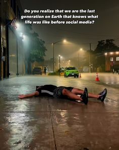 a man laying on the ground in front of a green car with an ad about it