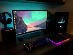 a computer monitor sitting on top of a wooden desk next to a keyboard and mouse