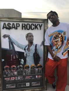 a man standing in front of a poster