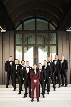 a group of men in tuxedos standing on steps