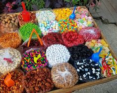 a wooden box filled with lots of different types of candies and nuts on display