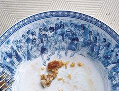 a blue and white plate with food on top of it next to utensils