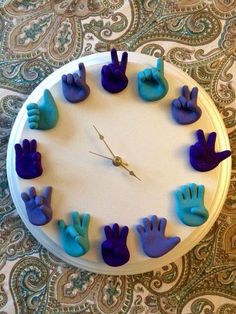 a clock with blue and purple hand prints on it