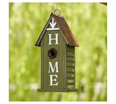 a green birdhouse with the word home painted on it