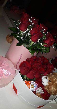 a teddy bear in a pink box with roses