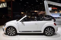 a small white car on display at an auto show