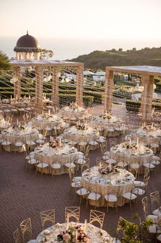 an outdoor venue with tables and chairs set up for a formal function at the beach