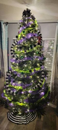 a decorated christmas tree with purple and green lights