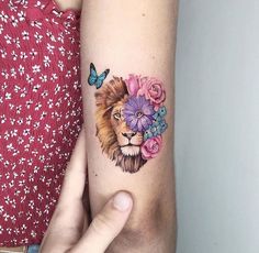 a woman's arm with a lion and flowers tattoo on it