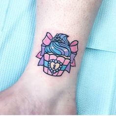 a woman's foot with a cupcake tattoo on it