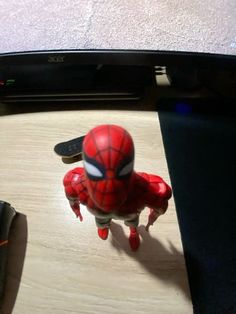 a toy spider man is standing on a table