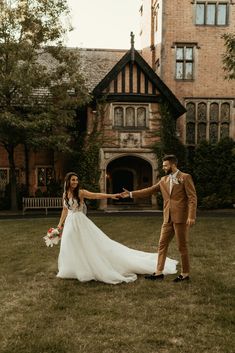 a bride and groom holding hands in front of a large building