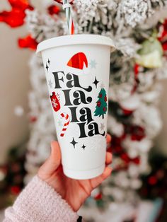 a person holding up a paper cup with the words fa la la la on it