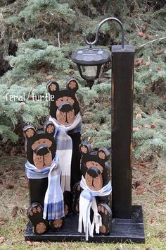 a group of teddy bears sitting on top of a black pole next to a lamp post