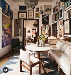 a living room filled with furniture and pictures on the wall