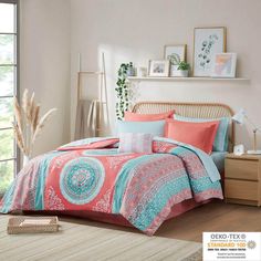 a bed with pink and blue comforters in a room