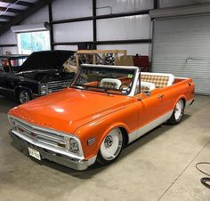 an orange convertible car parked in a garage