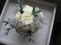 a bouquet of white roses and baby's breath is displayed on an iphone screen