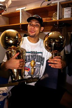 a man holding three golden trophies in his hands