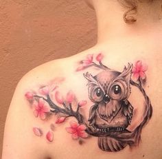 an owl sitting on a tree branch with flowers around it's neck and back