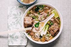 a bowl of soup with meat, noodles and vegetables