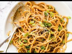 a white plate topped with noodles and peas