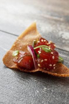 a piece of food that is sitting on some kind of bread with sesame seeds and ketchup