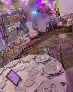 a table set up for a wedding reception with plates and silverware on the tables