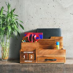 a wooden desk with a plant and calendar on it