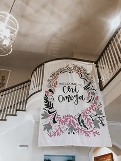 a welcome sign hanging from the side of a stair case in a house with stairs and railings