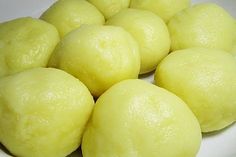 a white plate topped with yellow balls of dough