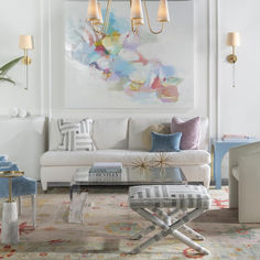 a living room filled with furniture and a painting on the wall above it's coffee table