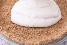 a pie crust with white icing on it sitting in a glass pan, ready to be baked