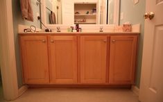 a bathroom with wooden cabinets and white walls