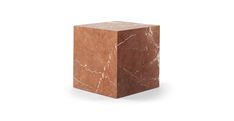 a brown marble block sitting on top of a white surface