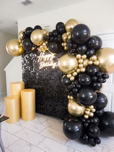 black and gold balloon arch with happy new year written on the front, surrounded by balloons